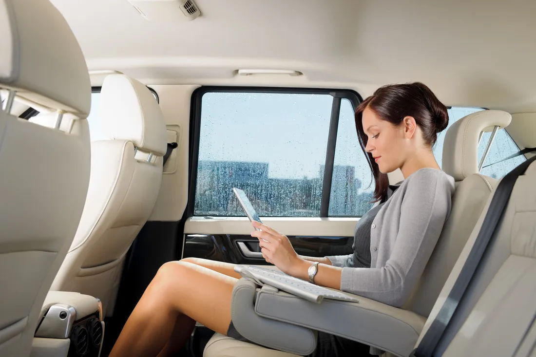 Passenger working in the back of a chauffeured car on the way to LAX