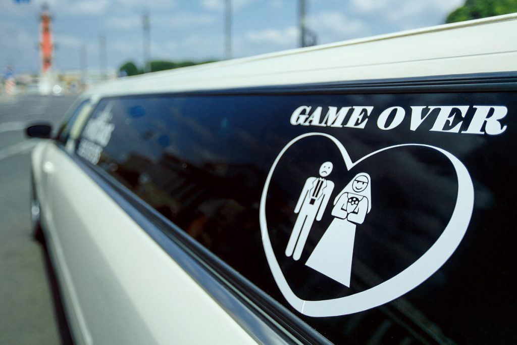 White stretch limousine with a Game Over bachelor decal