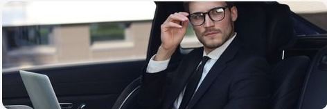 Business traveler in the back of a chauffeured car