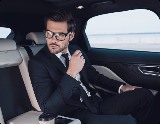 Traveler relaxing in the back of a chauffeured car