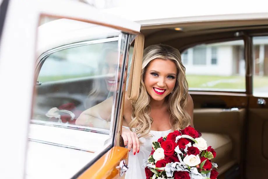 Bride smiling from a classic car